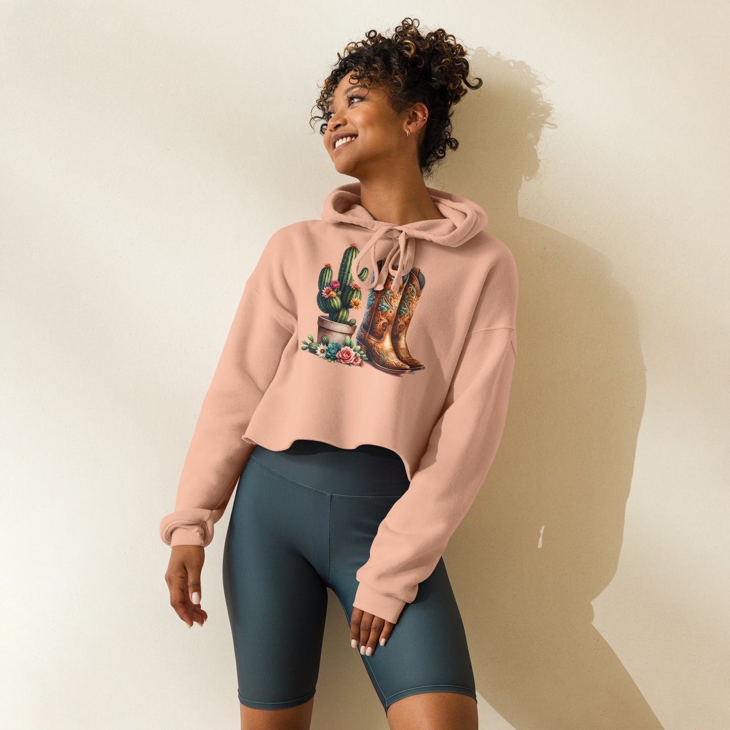Model in peach crop hoodie with colorful cowboy boot and cactus design