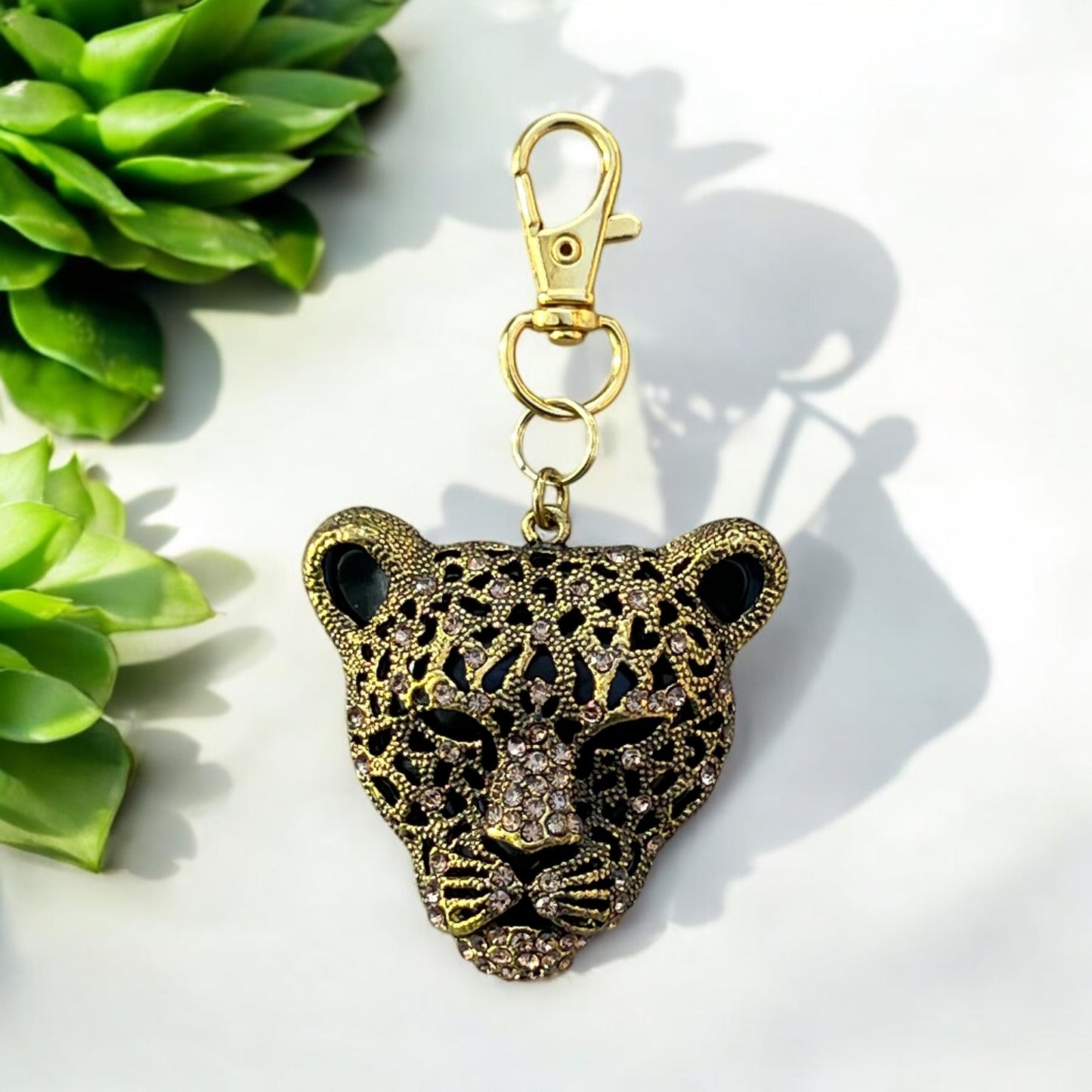 Purse charm detail showing antique brass and rhinestone finish