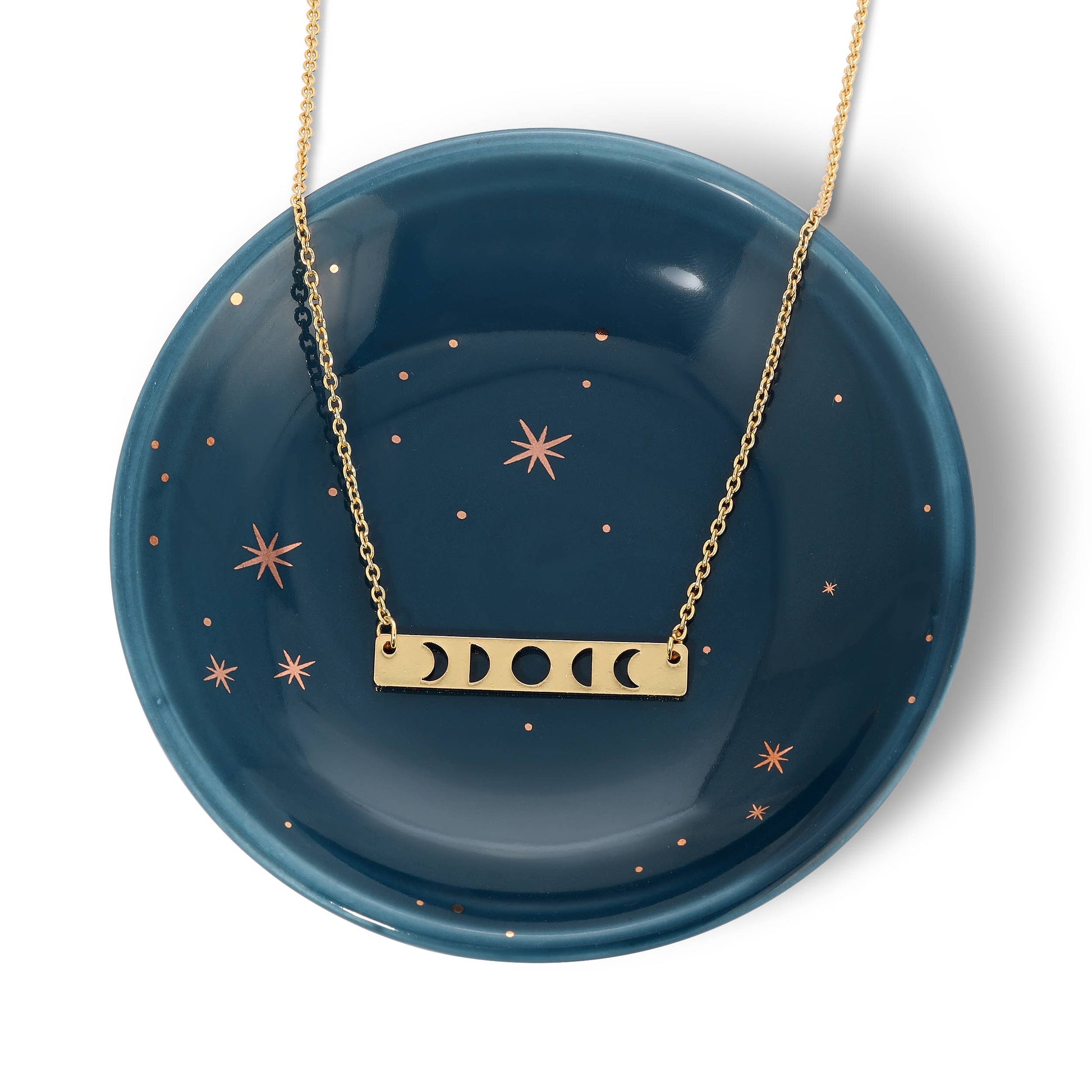 Flat lay of dainty gold moon phase necklace with minimalist celestial design