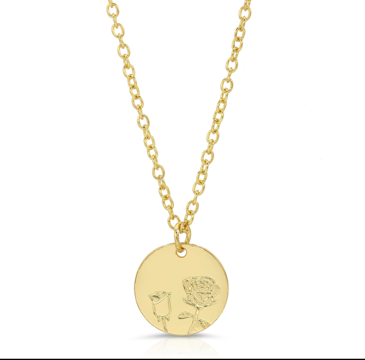 Close-up of gold rose pendant with delicate floral engraving on round charm