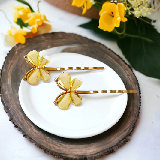 Gold tone bobby pins with acrylic yellow butterfly embellishments