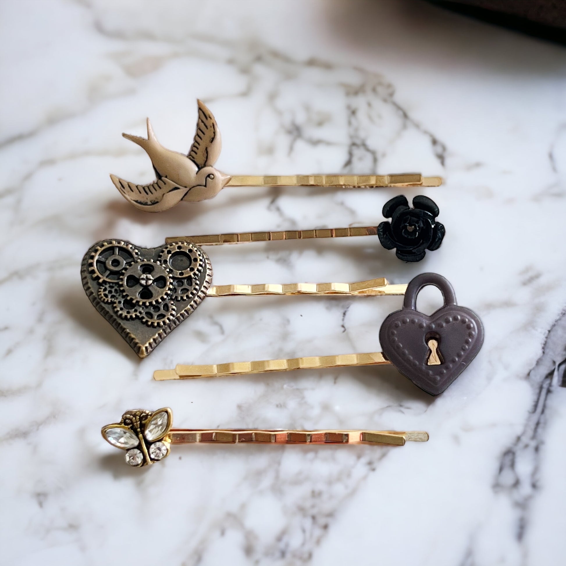 Steampunk hair pin set with heart, rose, bird, and lock on marble background