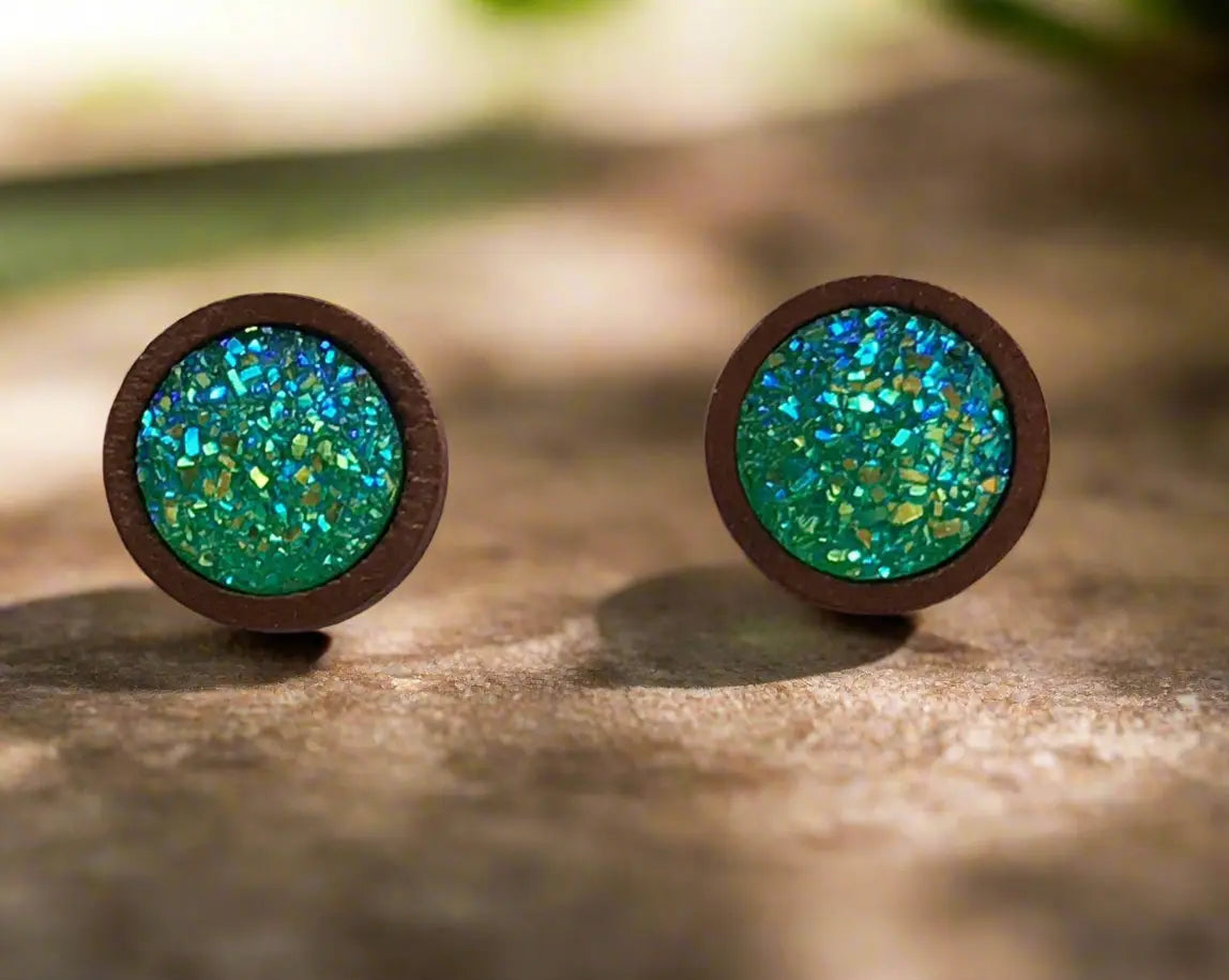 Round green druzy wood stud earrings displayed on a rustic wood surface