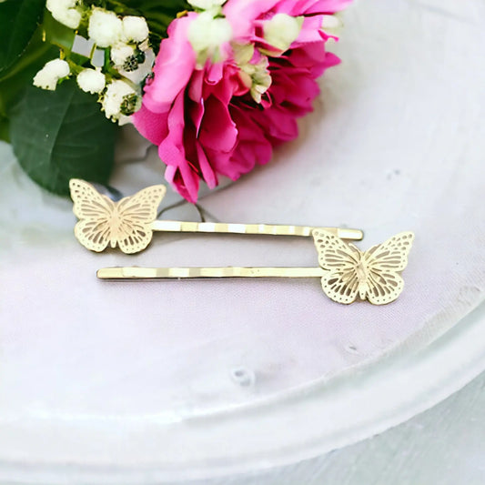 Close-up of gold bobby pins featuring filigree butterfly accents