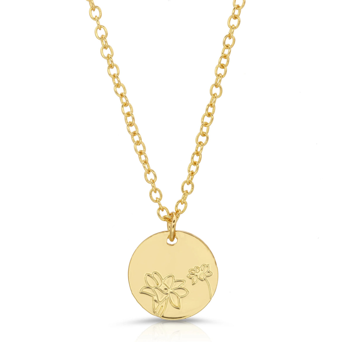 Close-up of dainty gold lily pendant with floral engraving