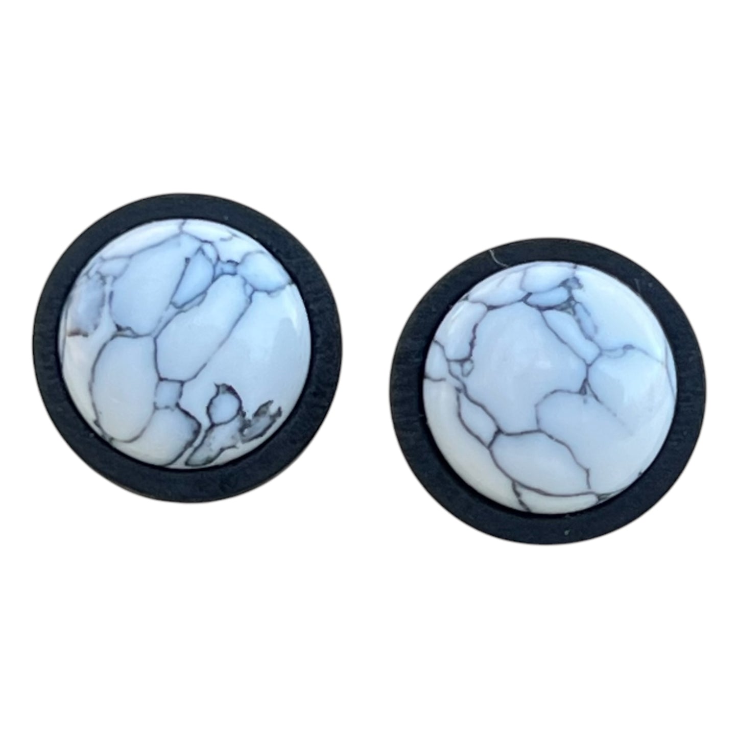 Close-up of minimalist white stone earrings in black wood bezel