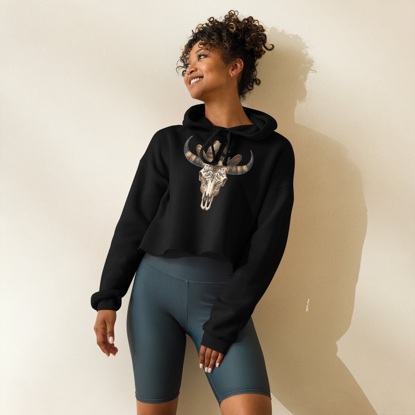 Side view of black crop hoodie with ornate skull and tooled cowgirl hat
