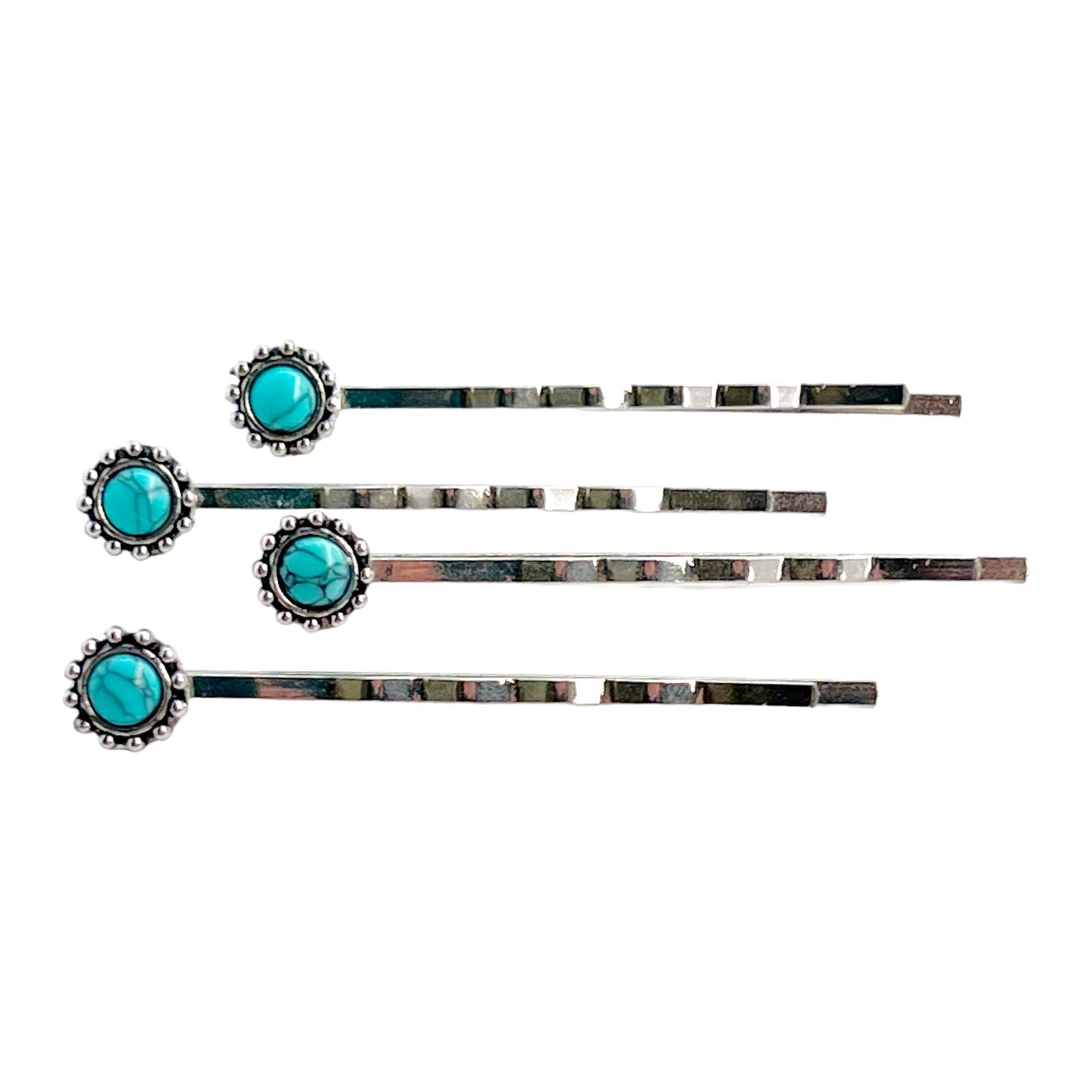 Silver-toned hair clips with turquoise stones placed on textured fabric