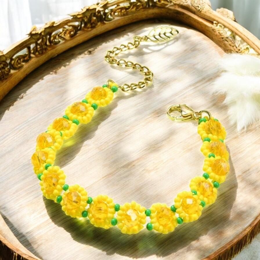 Flat lay of sunflower bracelet on neutral background with floral accents