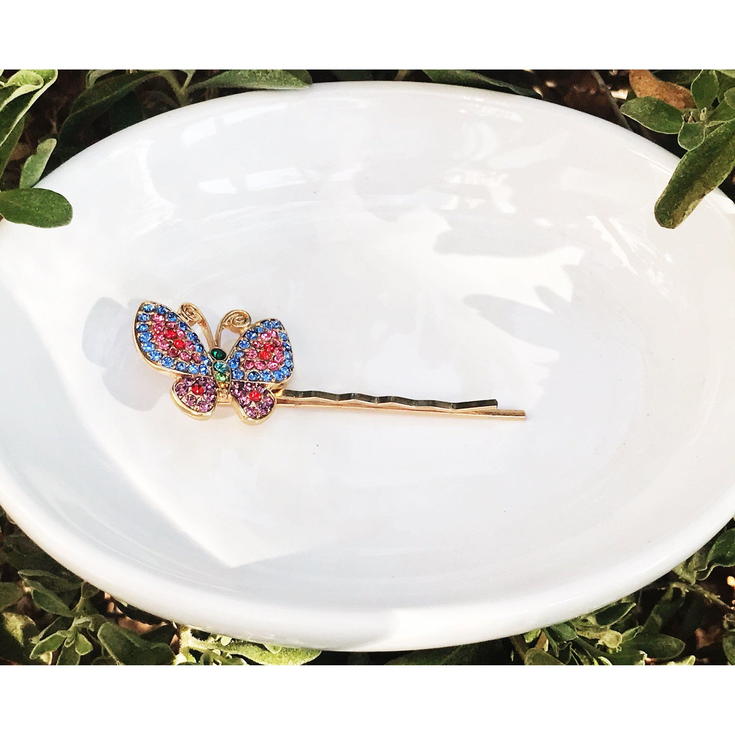 Colorful rhinestone butterfly bobby pins displayed on rustic wood