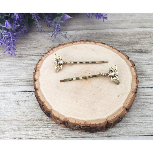 Close-up of gold-toned dragonfly hair clips with rhinestones