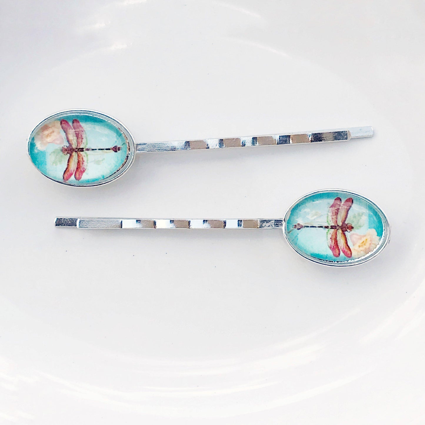 Side view of floral and dragonfly hair pins showing gold tone and detail