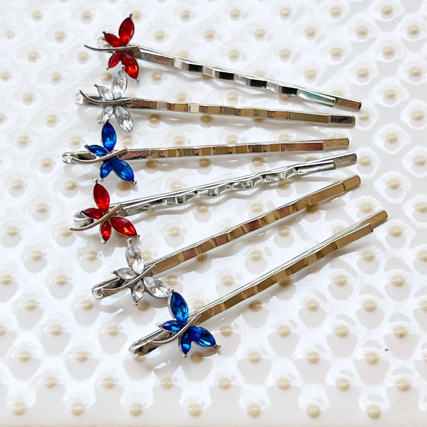 Size chart of red, white, and blue dragonfly hair pins with measurement grid