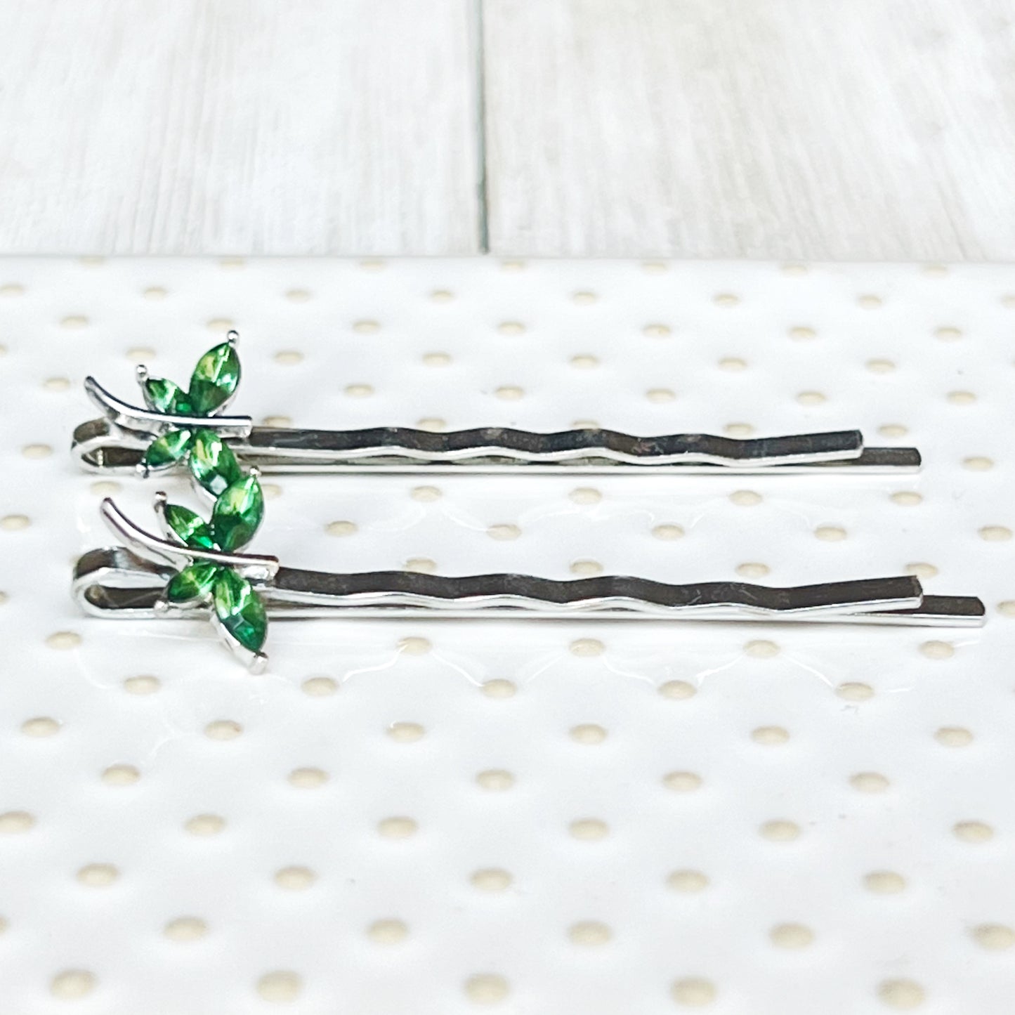 Size reference photo of green rhinestone dragonfly bobby pins on grid