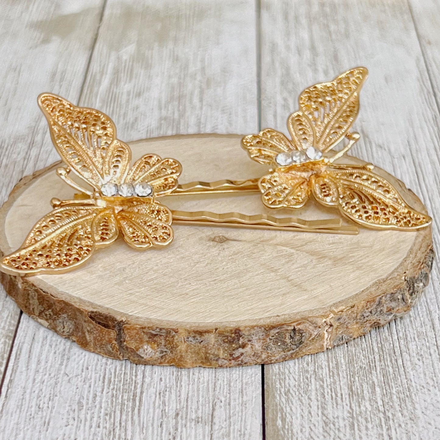 Gold butterfly hair clips displayed on marble background for gifting