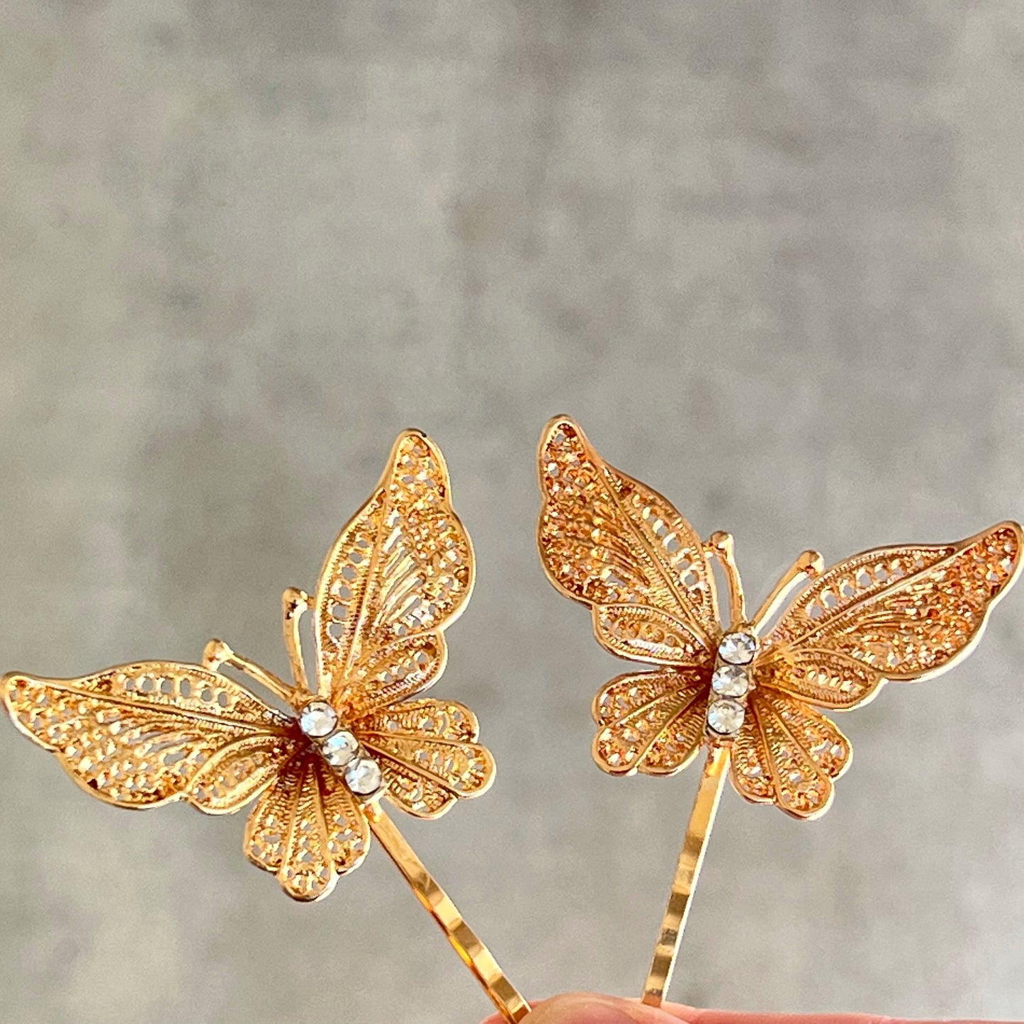 Close-up of gold filigree butterfly hair pin with rhinestone detail