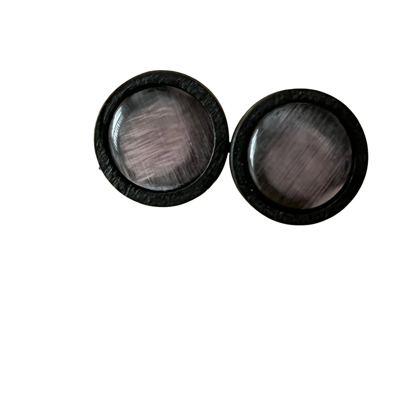 Pair of black circular earrings with glass centers on a white background