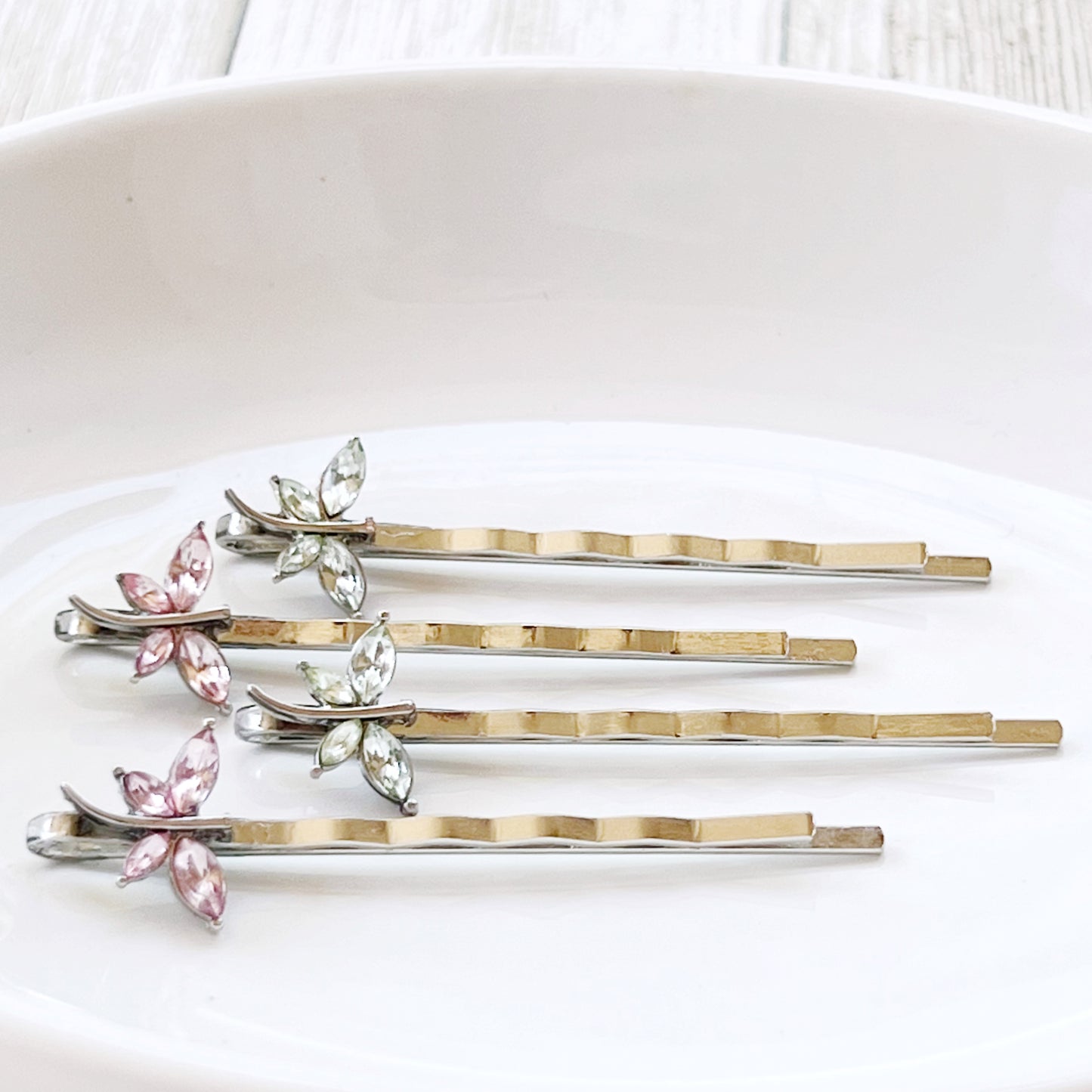 Light green and pink rhinestone dragonfly hair pins on white background