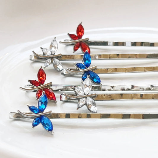 Set of red, clear, and blue dragonfly hair pins on white background – handmade festive accessories