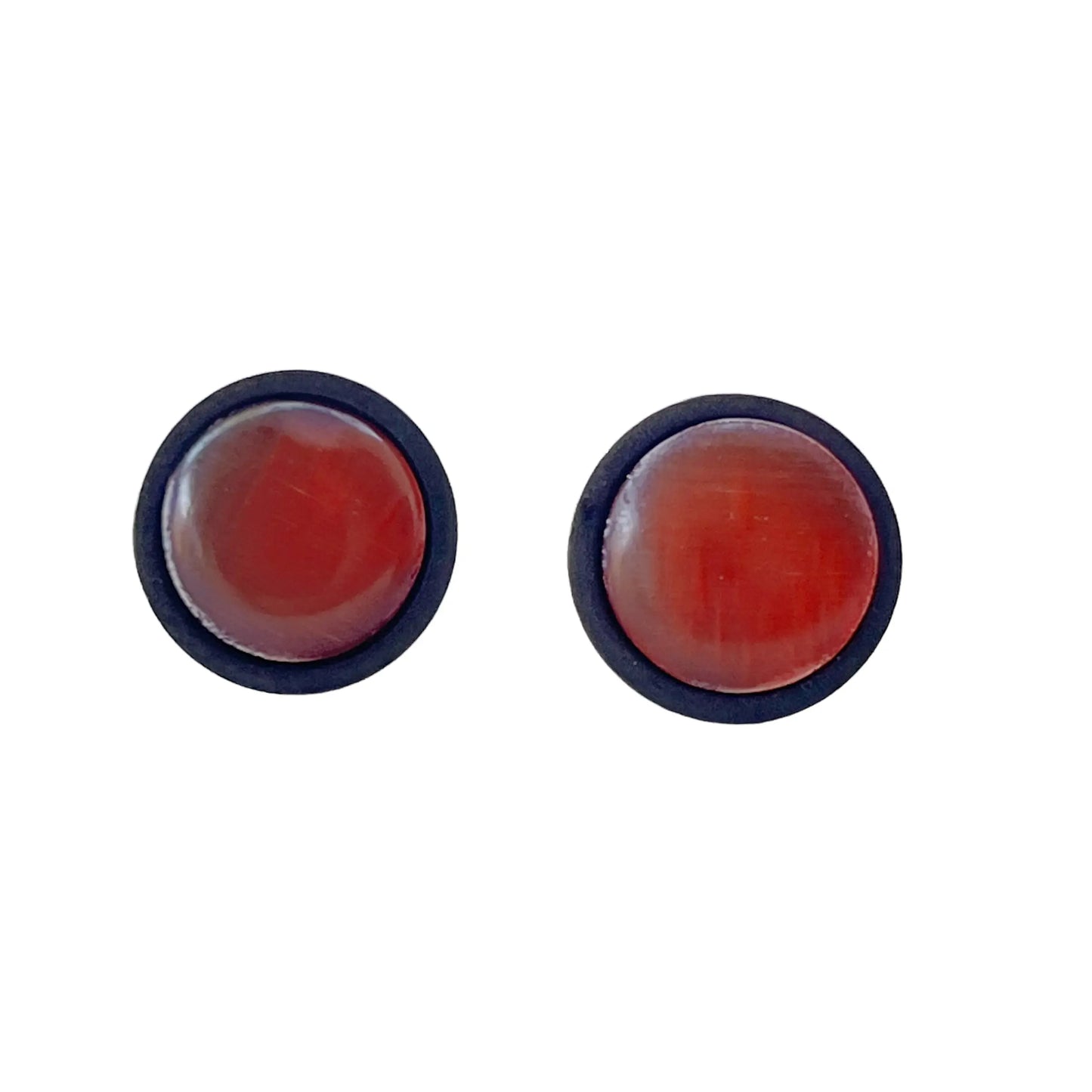 Pair of round earrings with orange glass on a white background