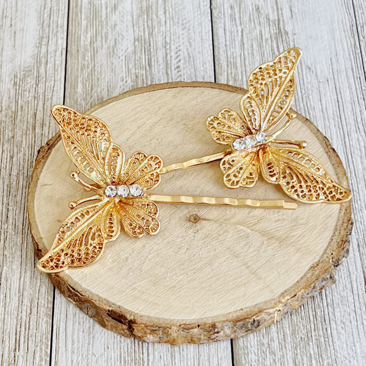 Gold butterfly hair pins styled with greenery for elegant look