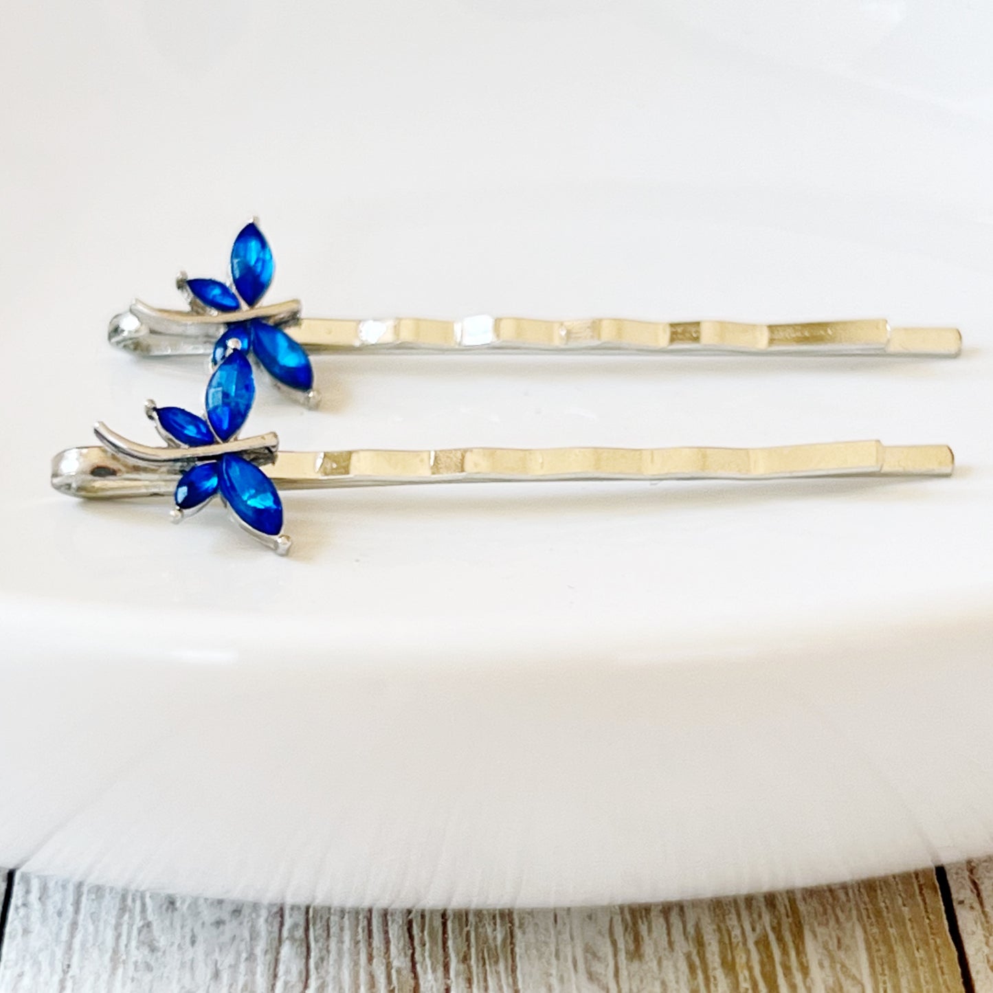 Pair of dainty blue dragonfly hair pins displayed on flatlay card for gifting