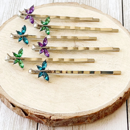 Close-up of whimsical crystal dragonfly bobby pins in bright colors