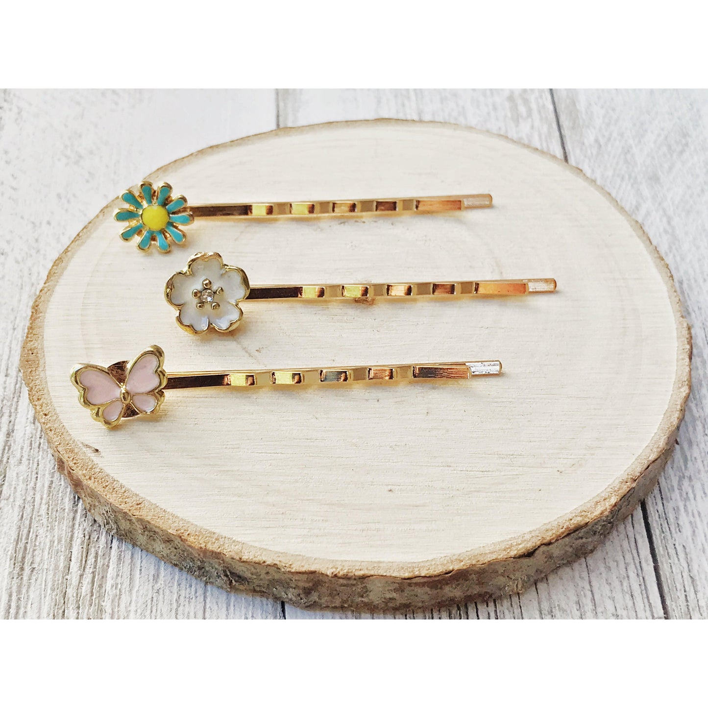 Whimsical butterfly and floral hair pins on wood slice