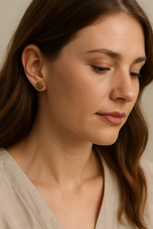 Close-up of a woman wearing lightweight wood and stainless steel earrings with a soft beige blouse, showing a comfortable style for sensitive ears.