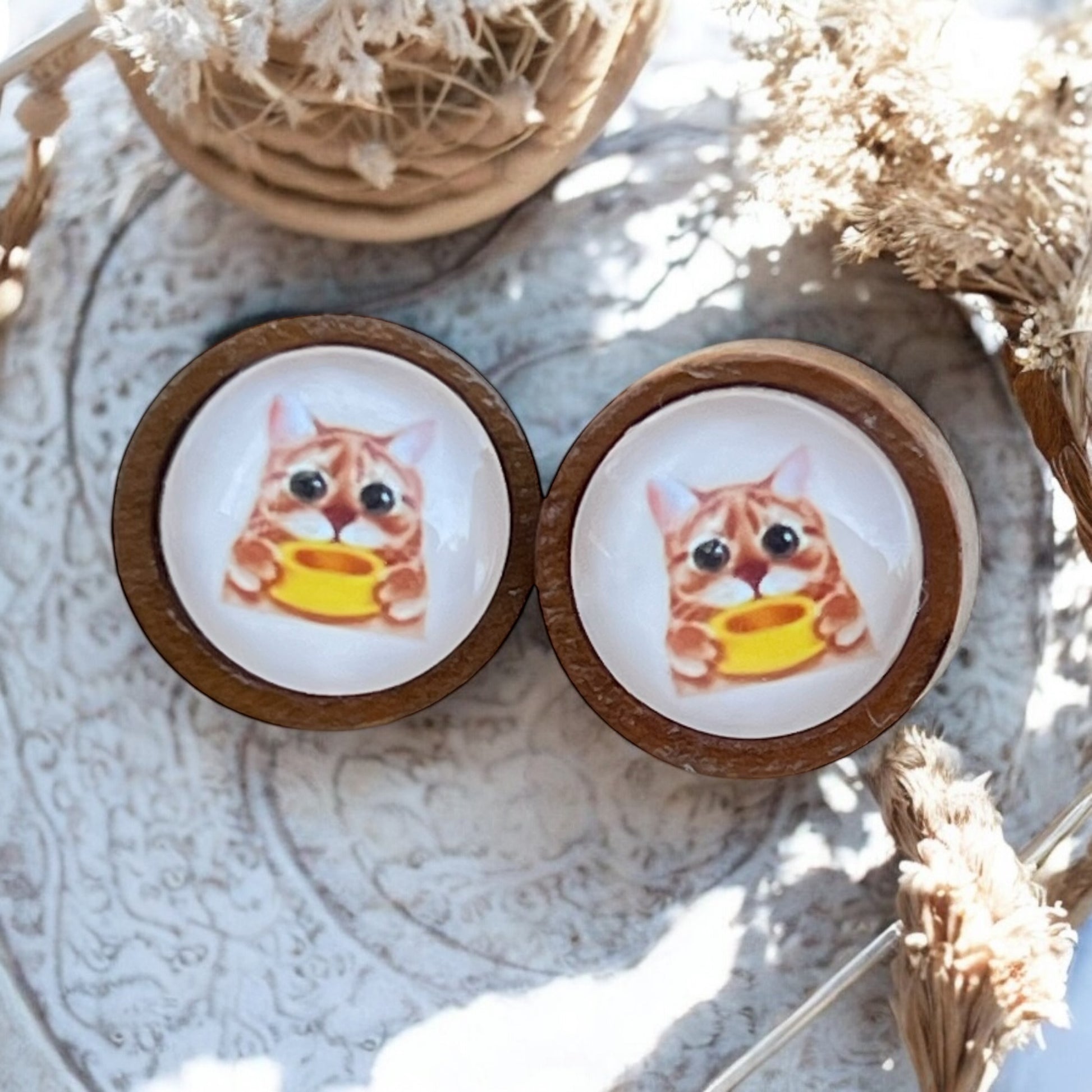 Close-up of 12mm cat earrings on wood background