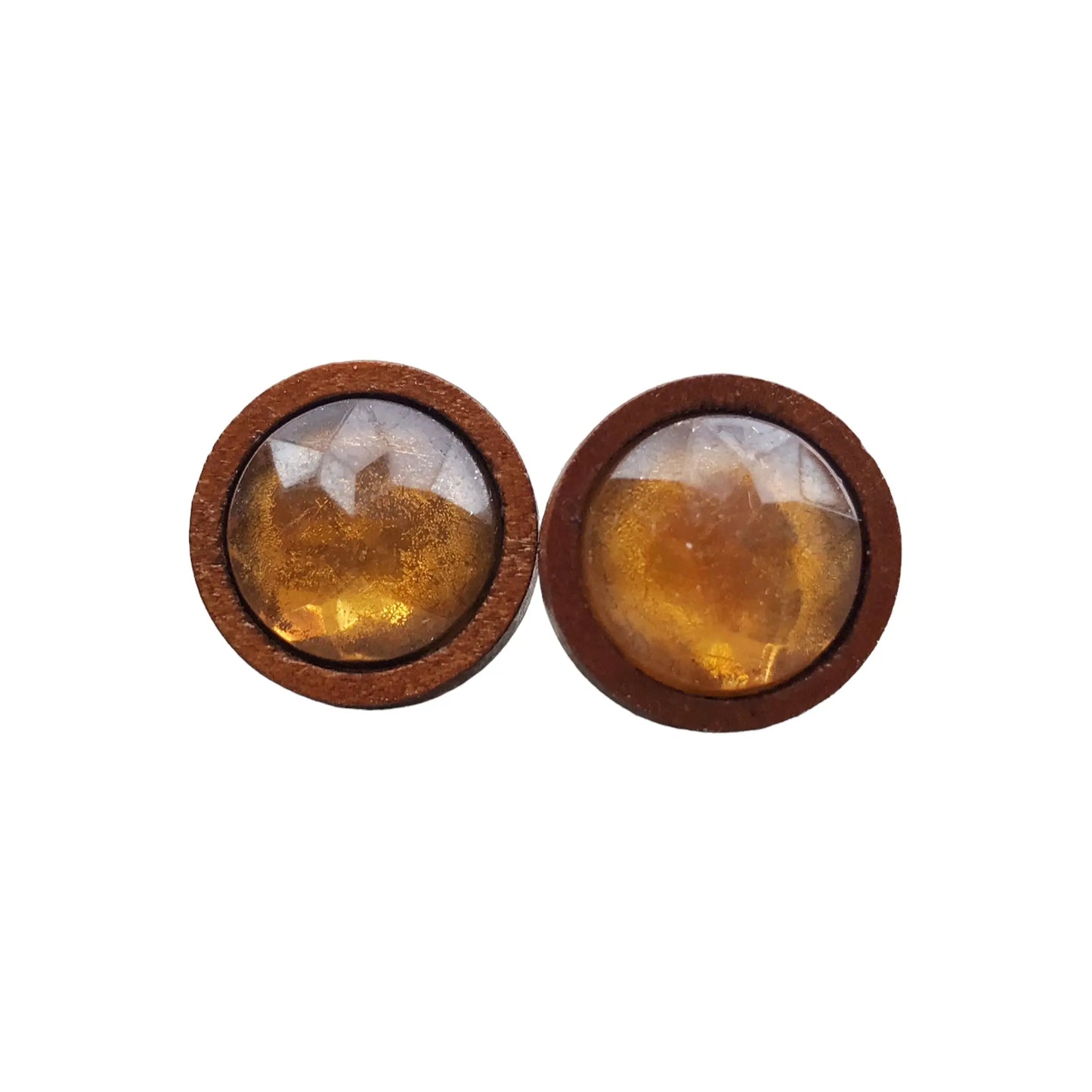 Round earrings with brown wooden frames and amber-colored stones on a white background