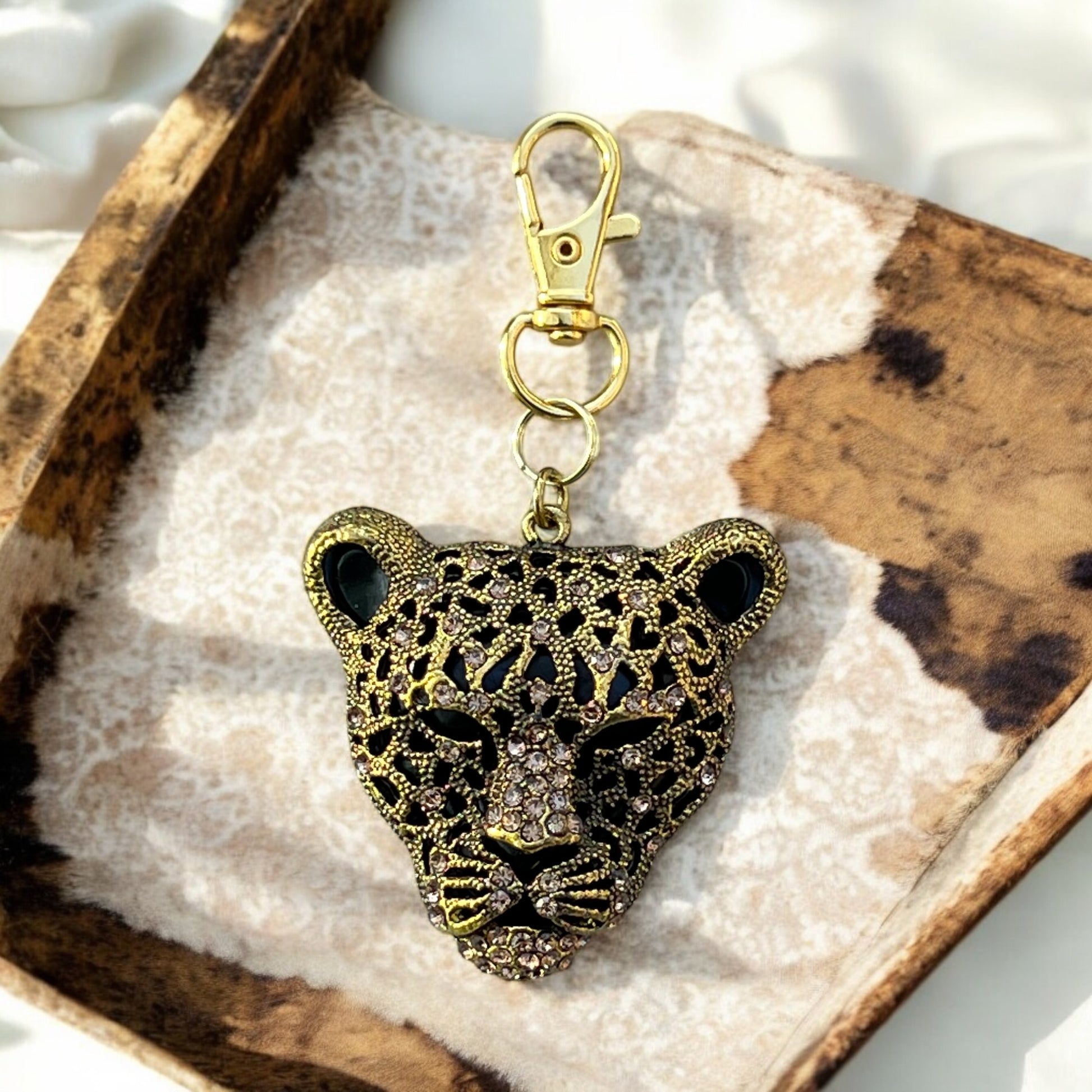 Bold animal print purse charm displayed with handbag