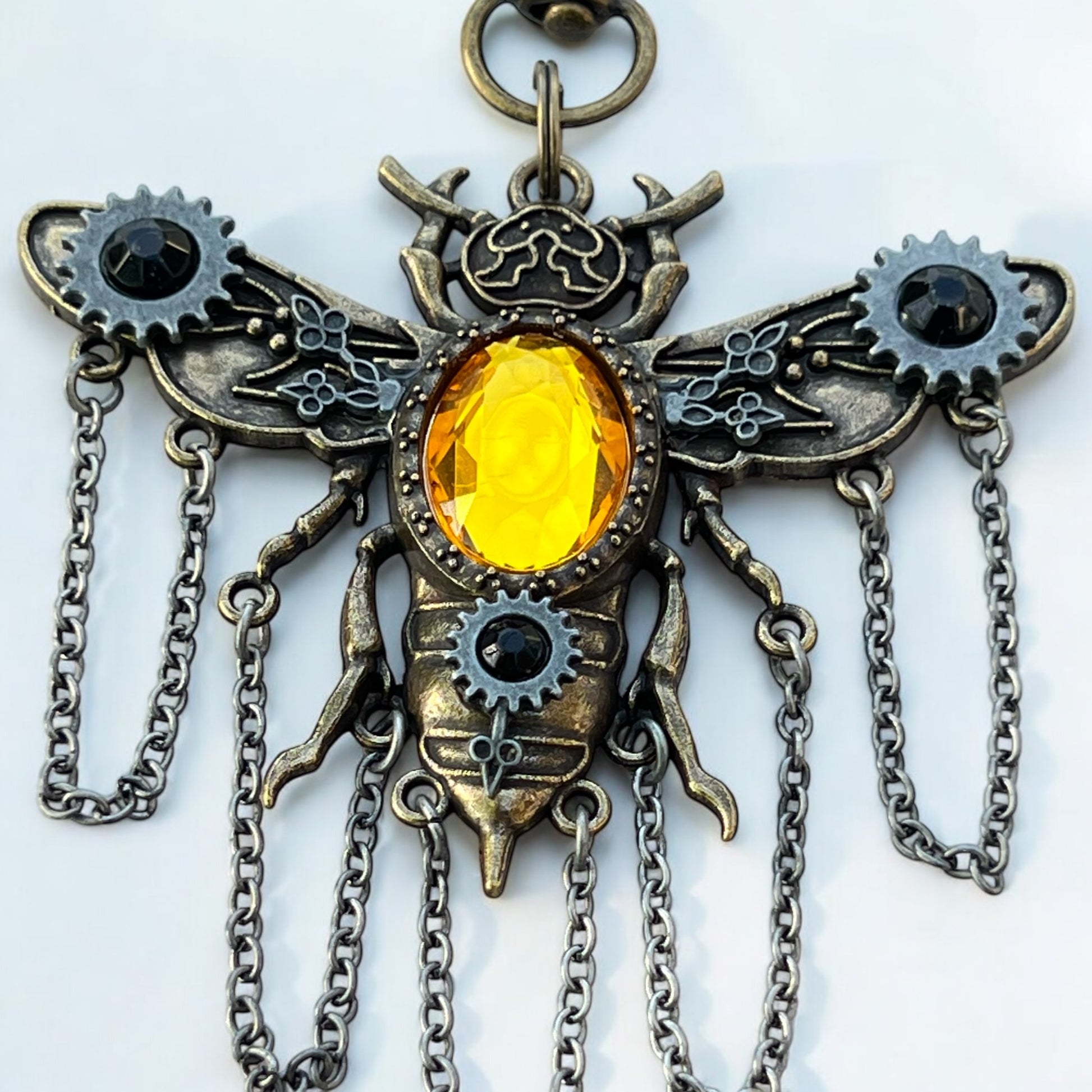 Steampunk bee charm styled with books and mystical props