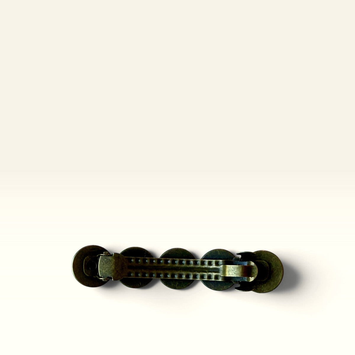 Backside and clasp mechanism of the single bronze-tone western hair barrette