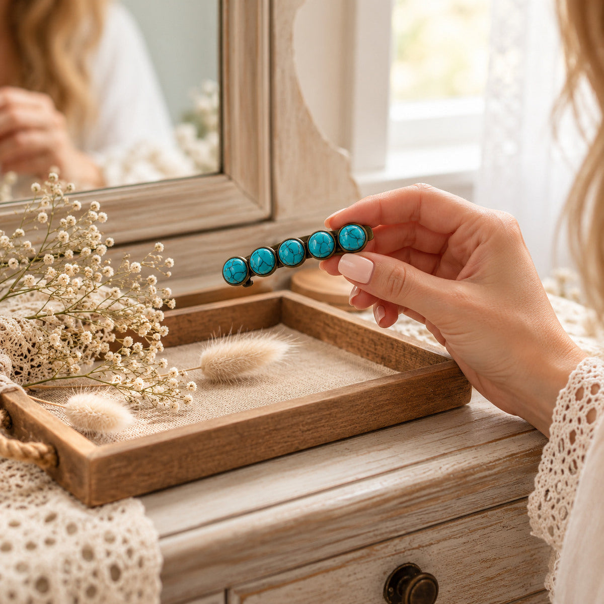 Hand selecting one turquoise western hair barrette at a natural wood vanity