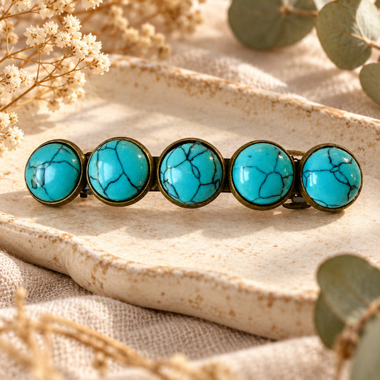Single bronze-tone western barrette with five faux-turquoise stones styled on a natural cream tray