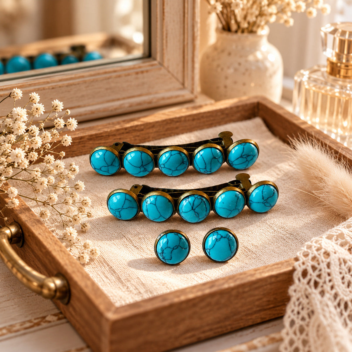 Two matching turquoise hair barrettes and a pair of stud earrings arranged on a rustic vanity tray
