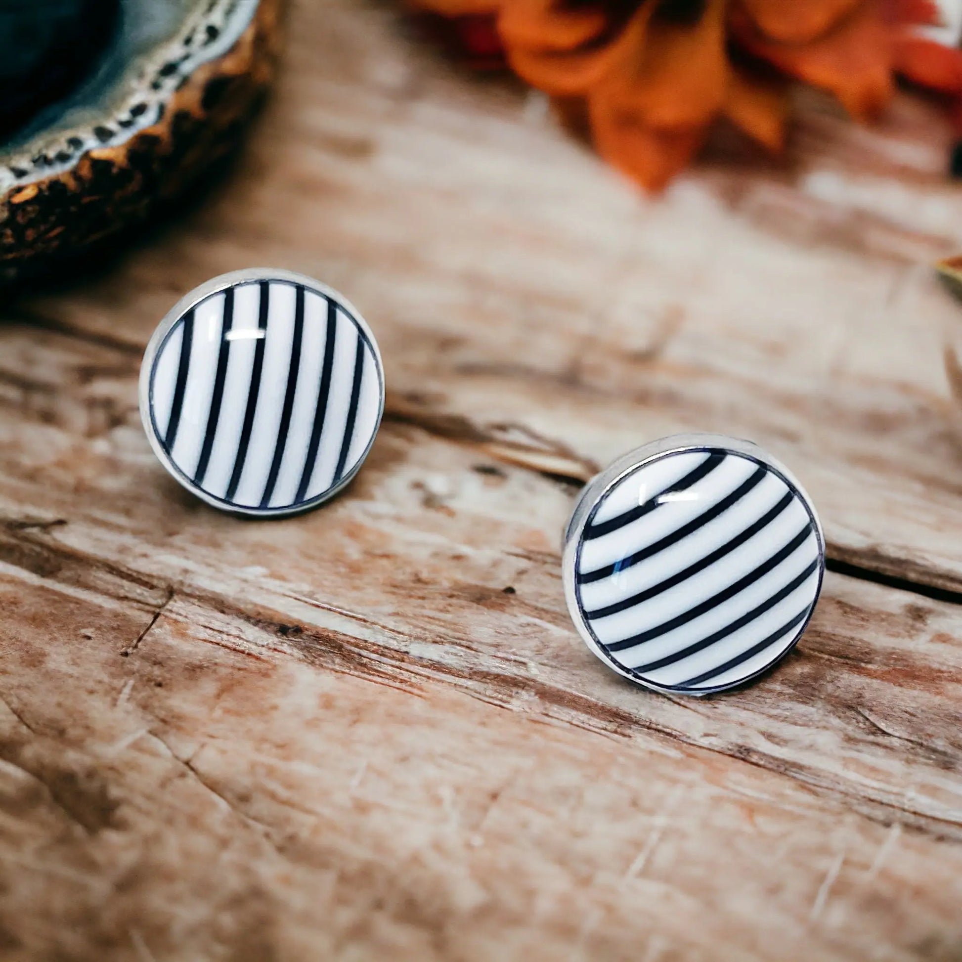 Black and white striped earrings on a wooden surface