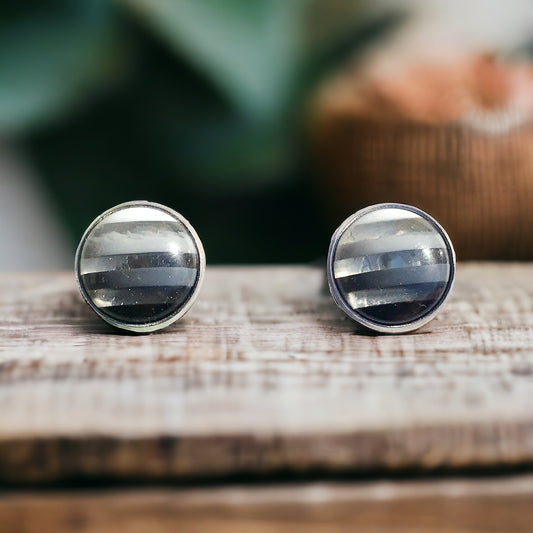 Black and white striped stud earrings with silver bezel on white background