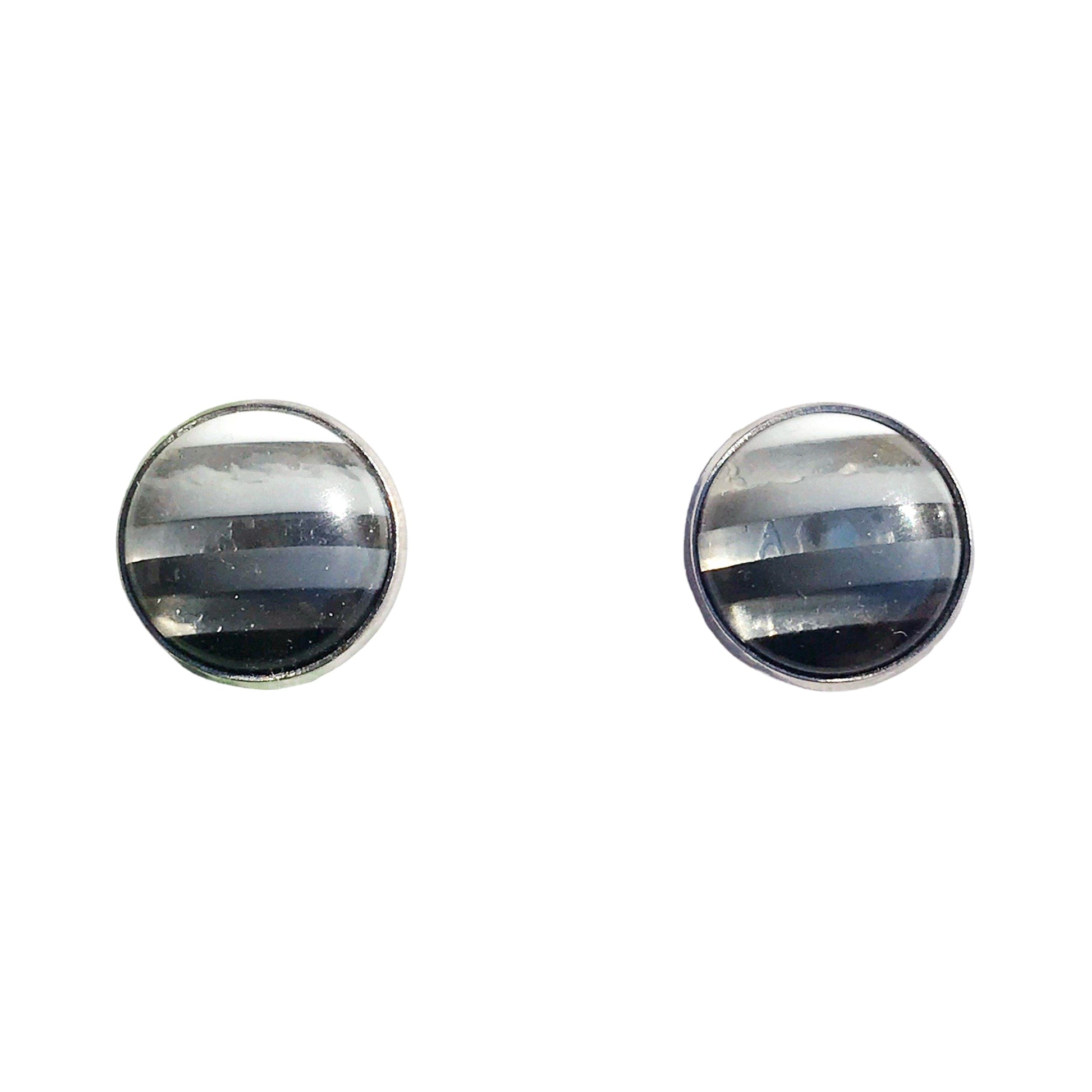 Silver bezel earrings laid flat on neutral background