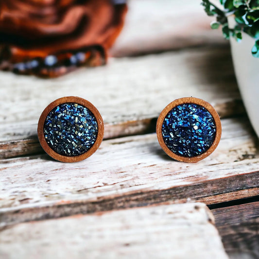 Round blue druzy wood stud earrings displayed on a rustic wood surface