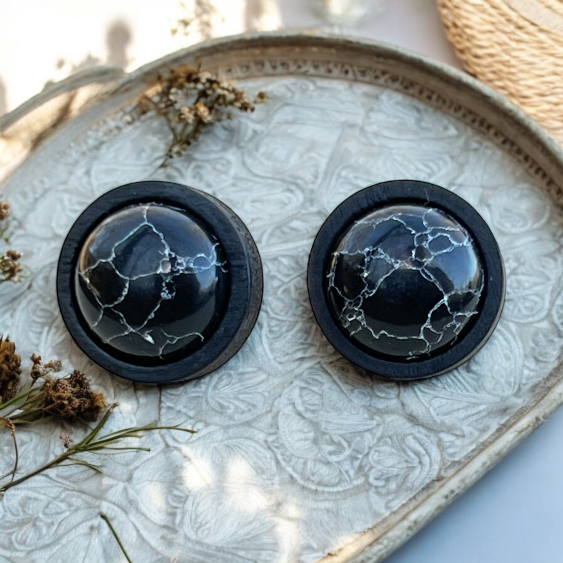 Bold minimalist earrings displayed on wood surface