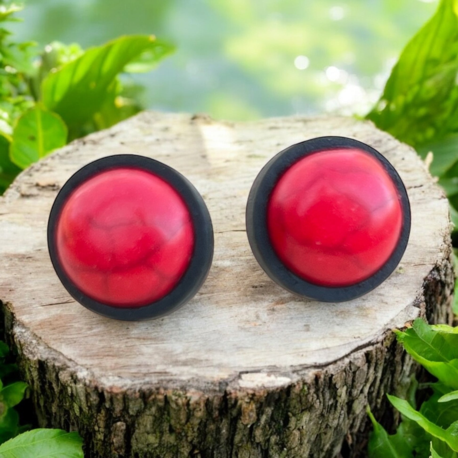 Close-up of bold minimalist red earrings in black wood bezels