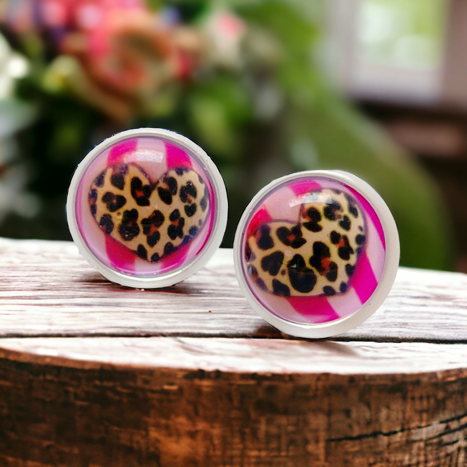 Flat lay of cheetah print heart stud earrings on neutral background