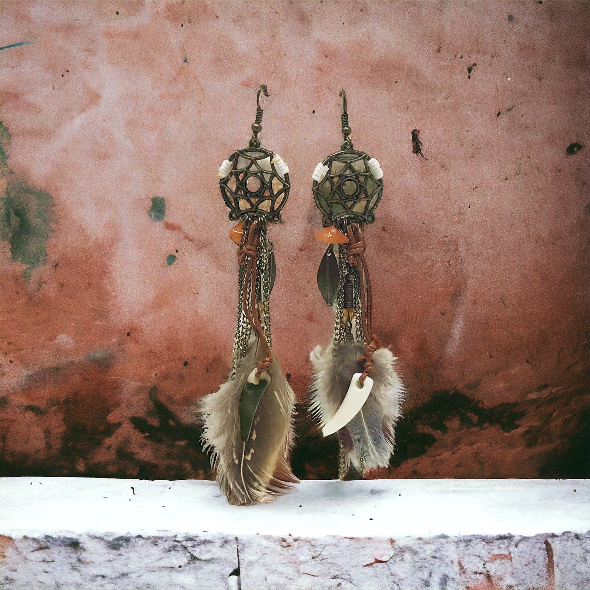 Boho feather statement earrings displayed with blurred natural props for soft, styled look