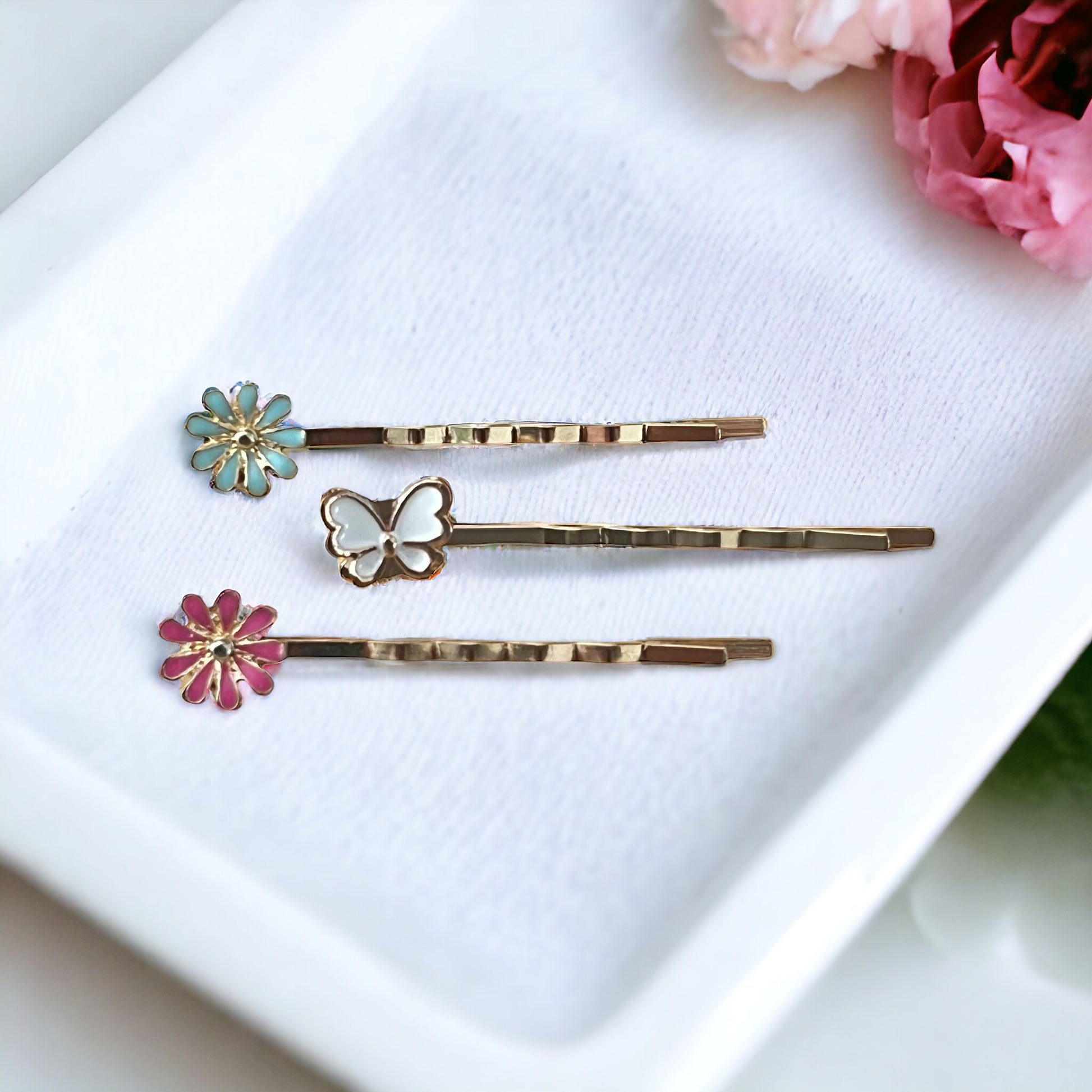Gold floral hair pins with pastel accents styled in a soft, feminine flatlay