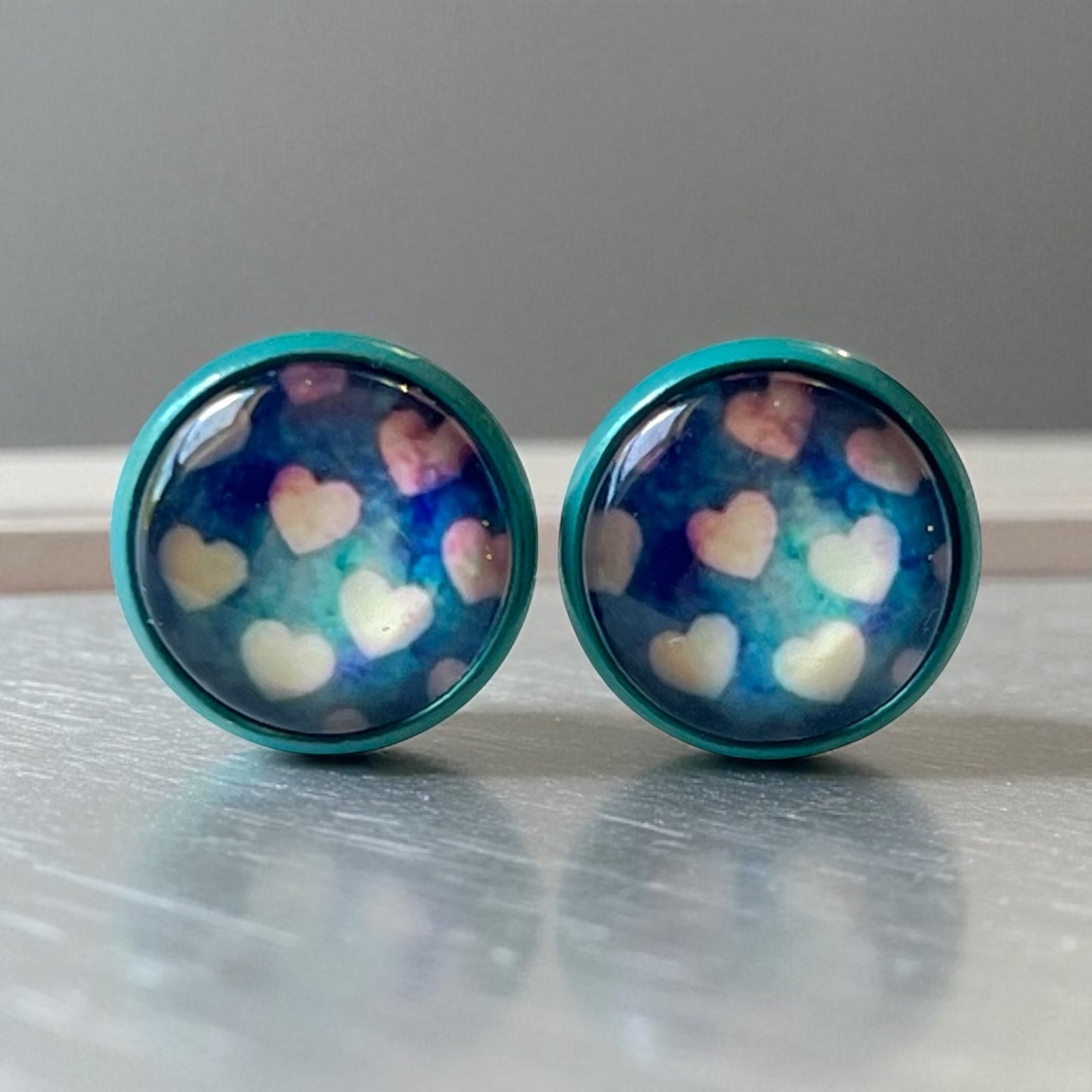 Pair of earrings with heart pattern on a metallic surface