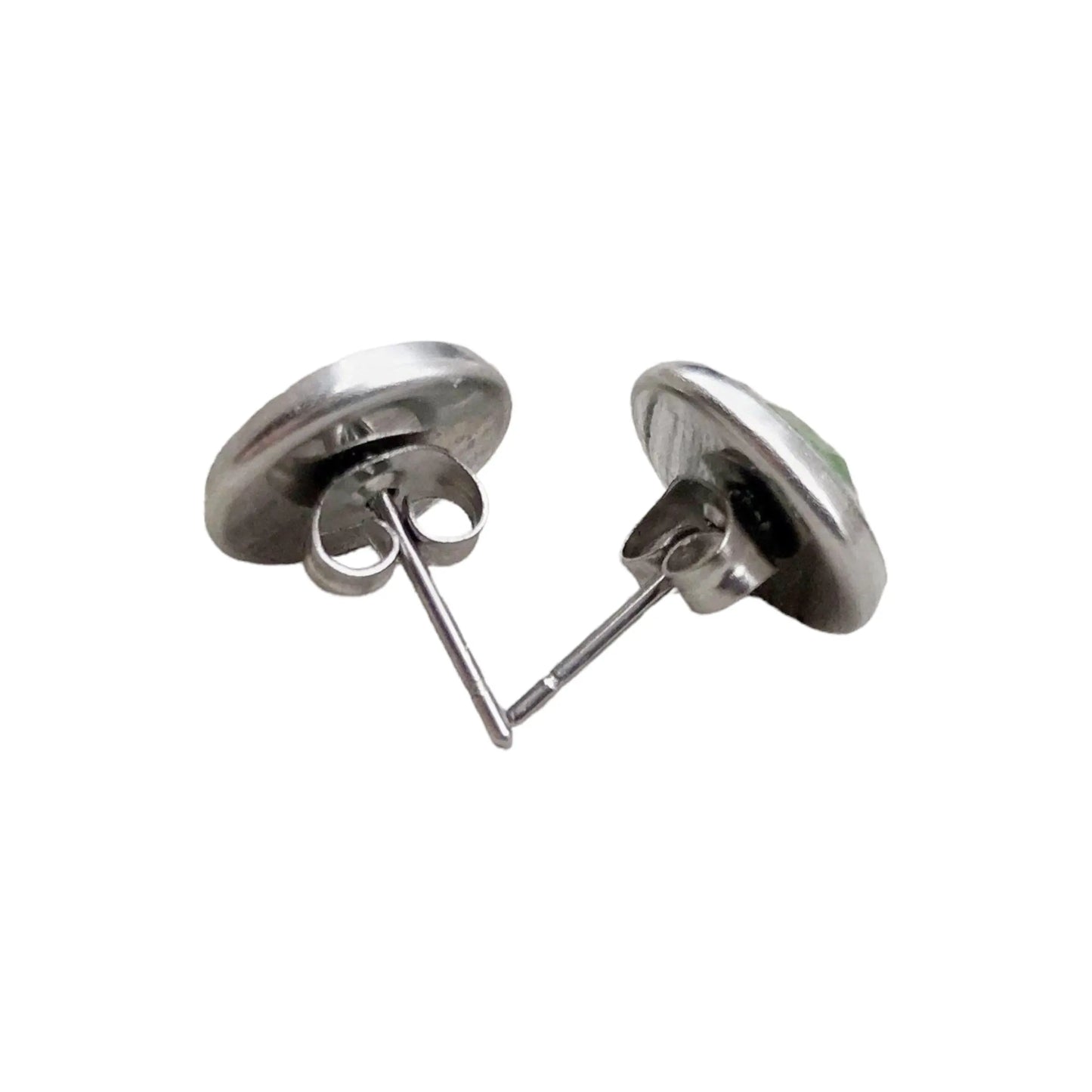 Back of a pair of green glitter silver stud earrings on a white background