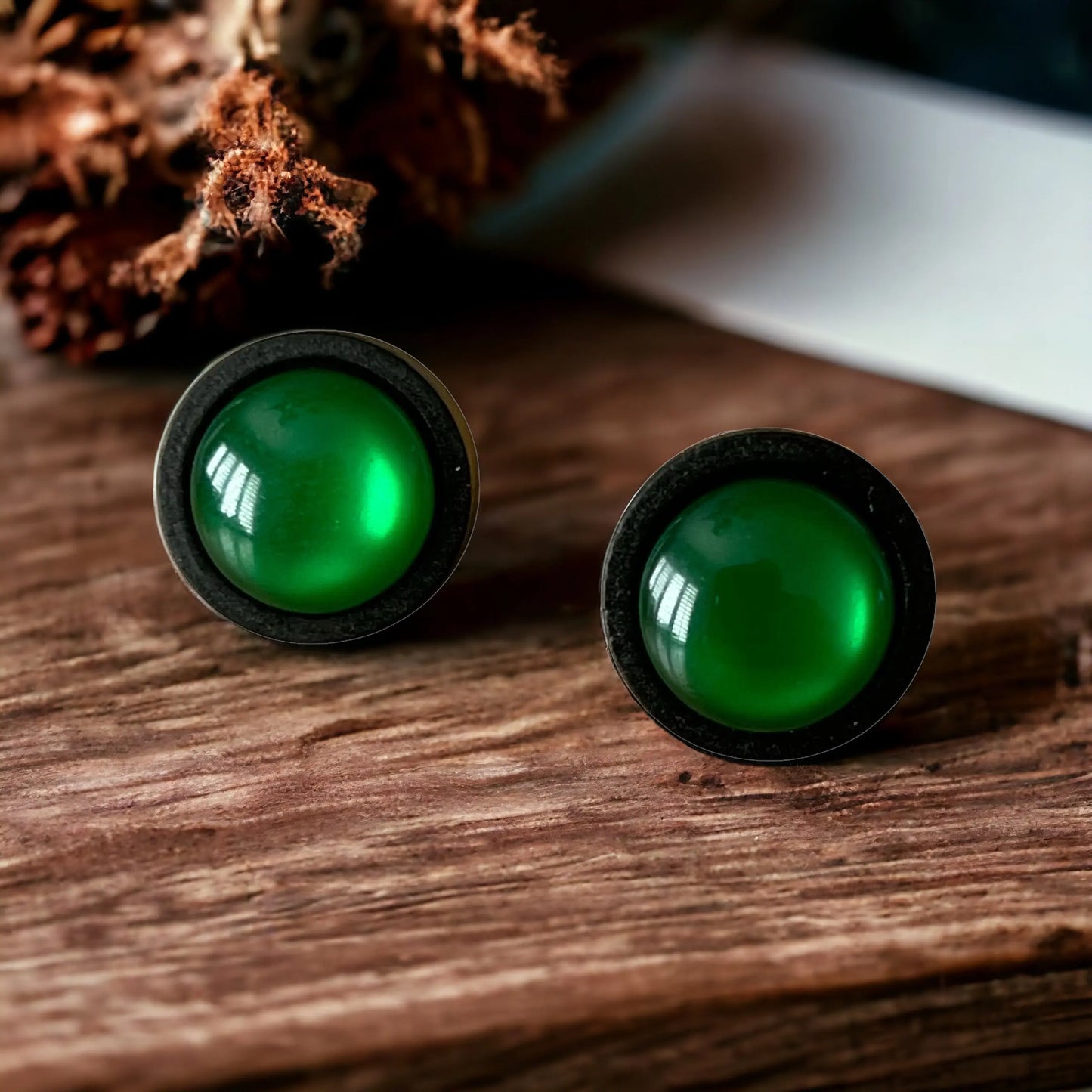 Pair of green earrings on a boho wooden surface