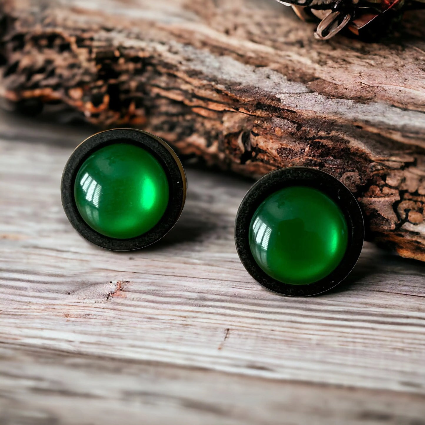 Green resin earrings on a wooden surface